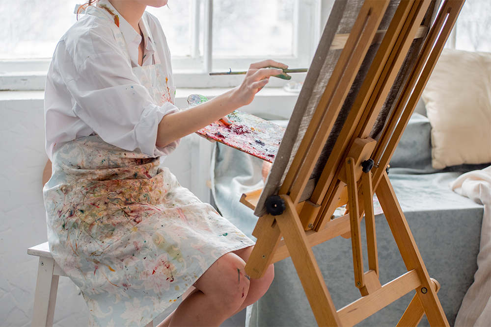 Artist sitting at an H frame studio easel