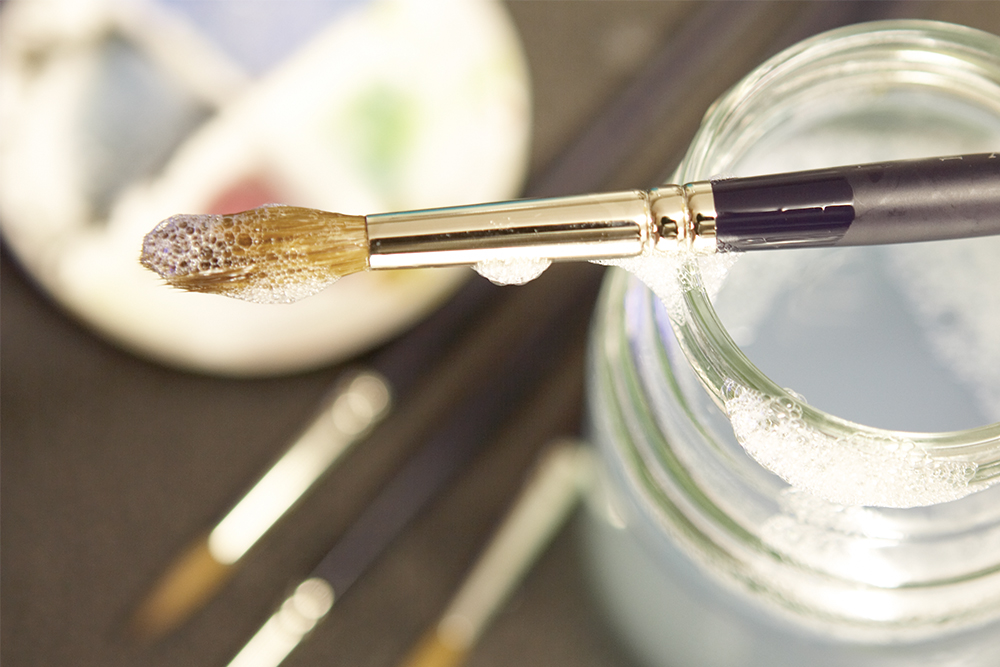 Artists paint brush being cleaned with soap and water
