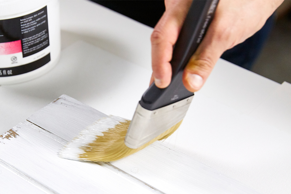 White Gesso being brushed onto a surface