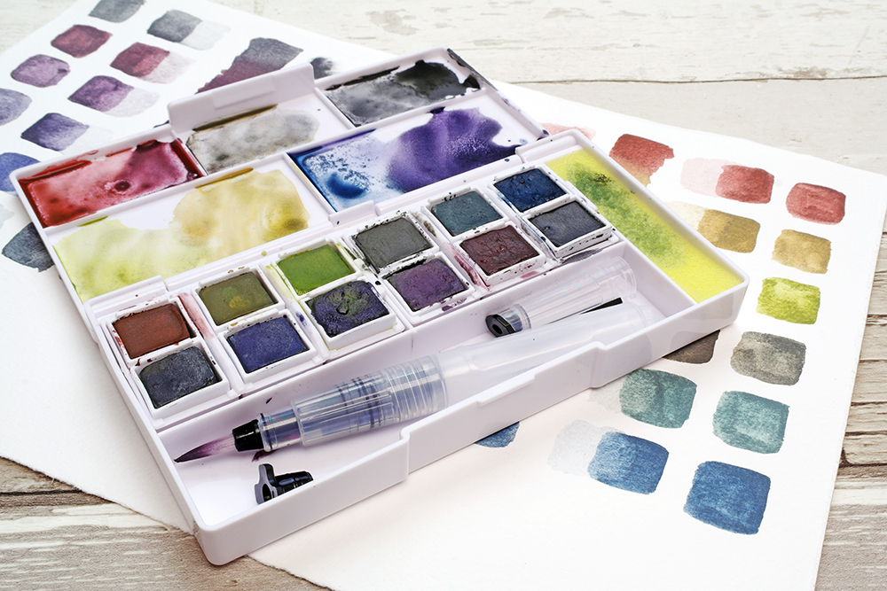 Derwent Graphitint Paint Pan Travel Set at angle with colour swatches