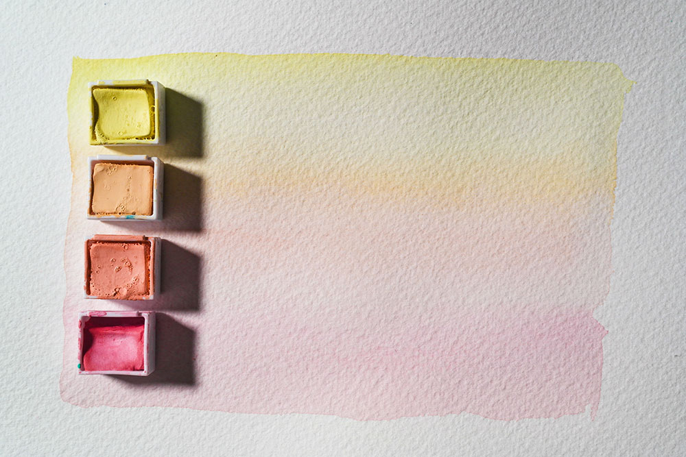 A dilute, gradated wash of Pastel Pan paint in Lemon, Peach, Coral Pink and Pink Flamingo.