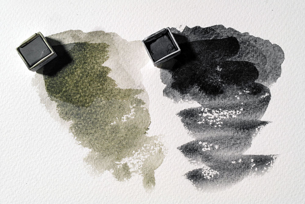 Dried swatches of Dark Moss and Dark have been reactivated with water. The original stroke is visible under a paler, more washy stroke.