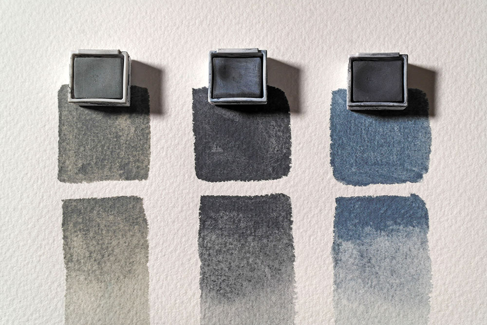 Painted swatches of Derwent TInted Charcoal in Forest Green, Ocean Deep and Mountain Blue. With another painted swatch below diluted with water.