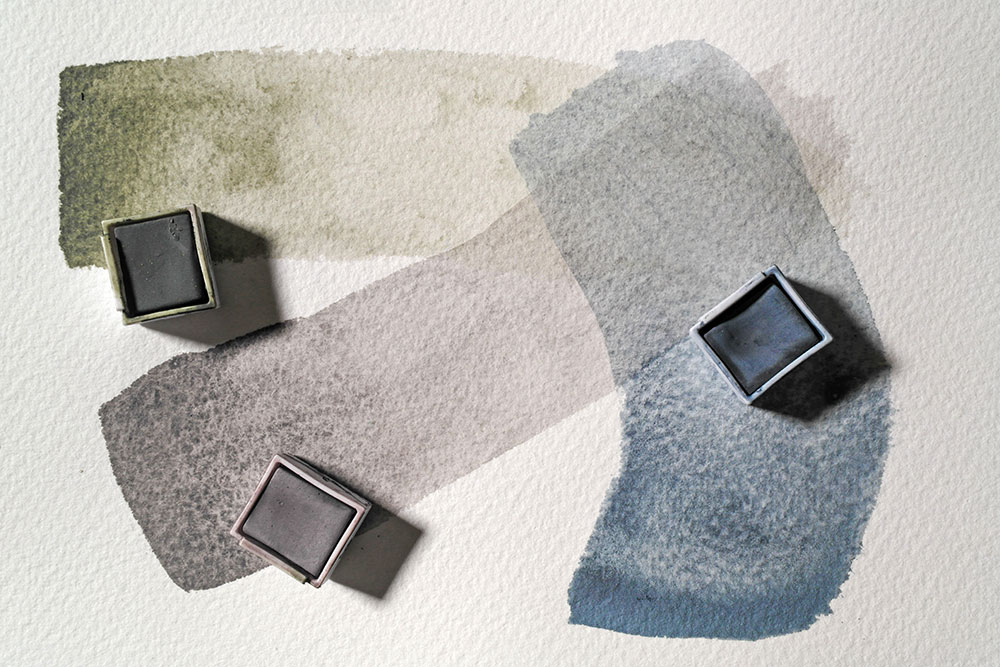 Broad sweeps of Derwent Tinted Charcoal in Dark Moss, Burnt Embers and Mountain Blue. The swatches become more dilute with the length of the stroke.