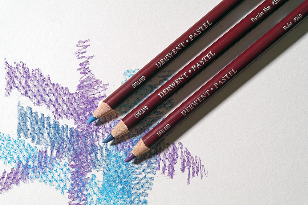 Experiment with Frottage - Derwent Pastel Pencils in light blue, dark blue and purple have been used to take rubbings from a textured surface.