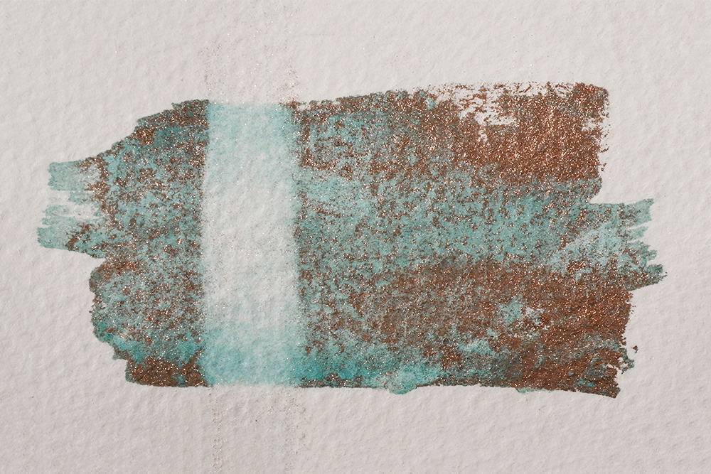 Swatch of Aqua Bronze mixed with watercolour and a line shown where it has been rewetted. 