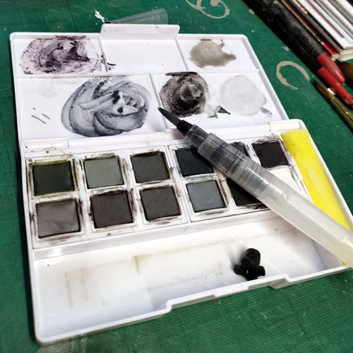 An open Derwent Tinted Charcoal Paint Pan Set showing the contents.