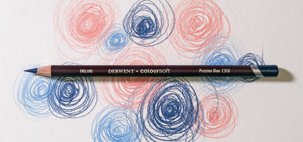 Derwent Coloursoft Wax Based Coloured Pencil on a colourful background