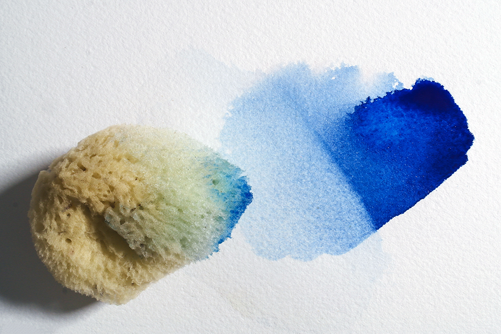 A sponge has been used to partially lift a wash of staining Phthalo blue paint.