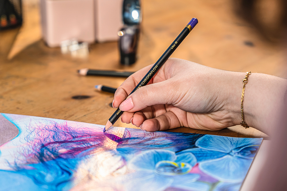 Artist using a purple Chromaflow colour pencil to draw