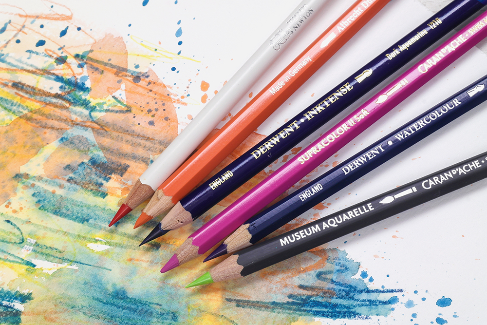 Assorted Artists' Watercolour Pencils photographed on a painted background.