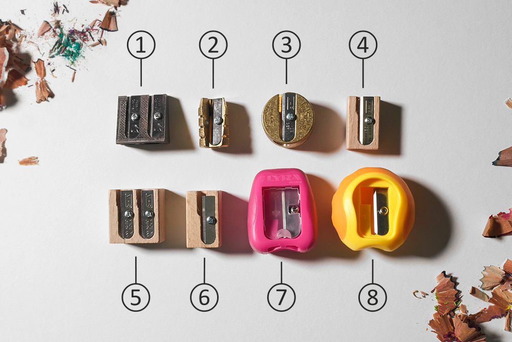 Assorted simple manual single blade pencil sharpeners on a white background, numbered.