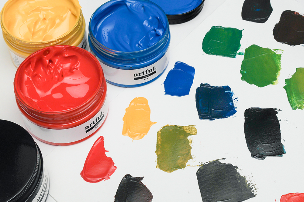 Four jars of artful screen printing inks in red, blue, yellow and black with painted swatches