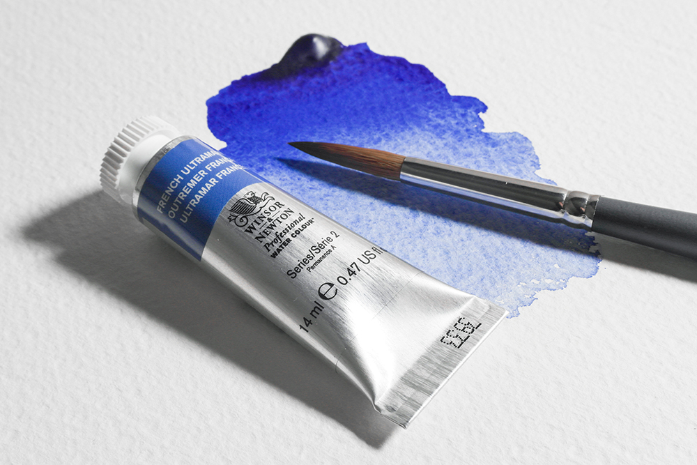 A tube of Winsor & Newton French Ultramarine Professional Watercolour Paint on a painted blue swatch