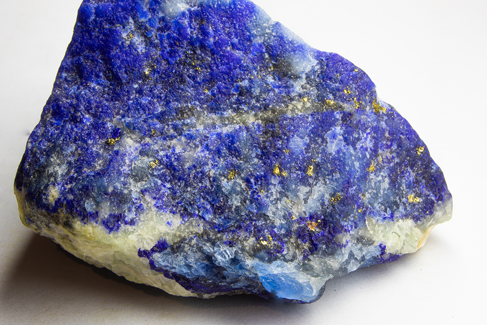 An unpolished chunk of Lapis Lazuli showing flecks of gold (iron pyrite) and white (calcite). This stone was used to make genuine ultramarine paint.