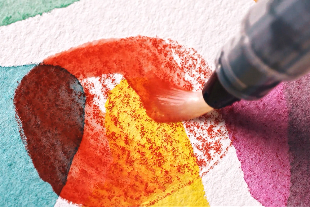 Artist layering washes of Inktense colour without reactivation