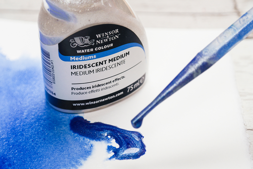 A bottle of Winsor & Newton Iridescent Medium and a pipette full of shimmering blue paint.