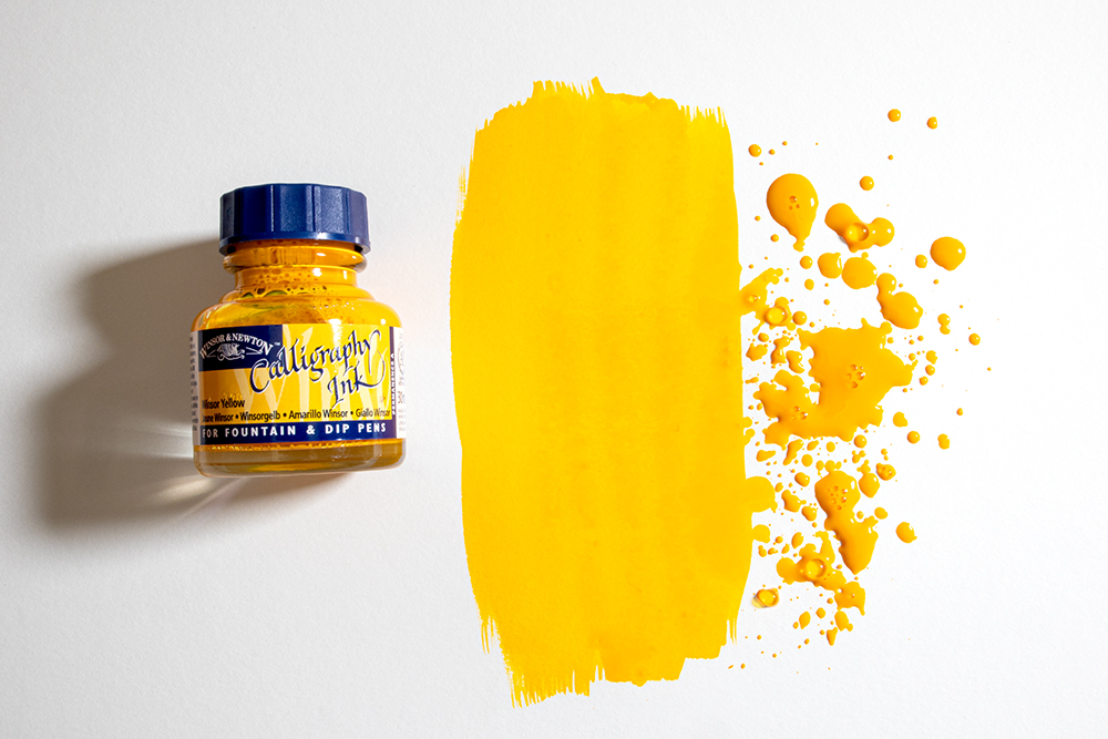 A bottle of Winsor & Newton Callgraphy Ink with a splattered swatch of colour