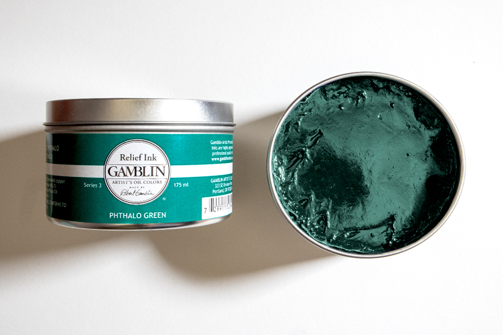 A tin of Gamblin Artist's Oil Colors Relief Ink with an open tin by its side.