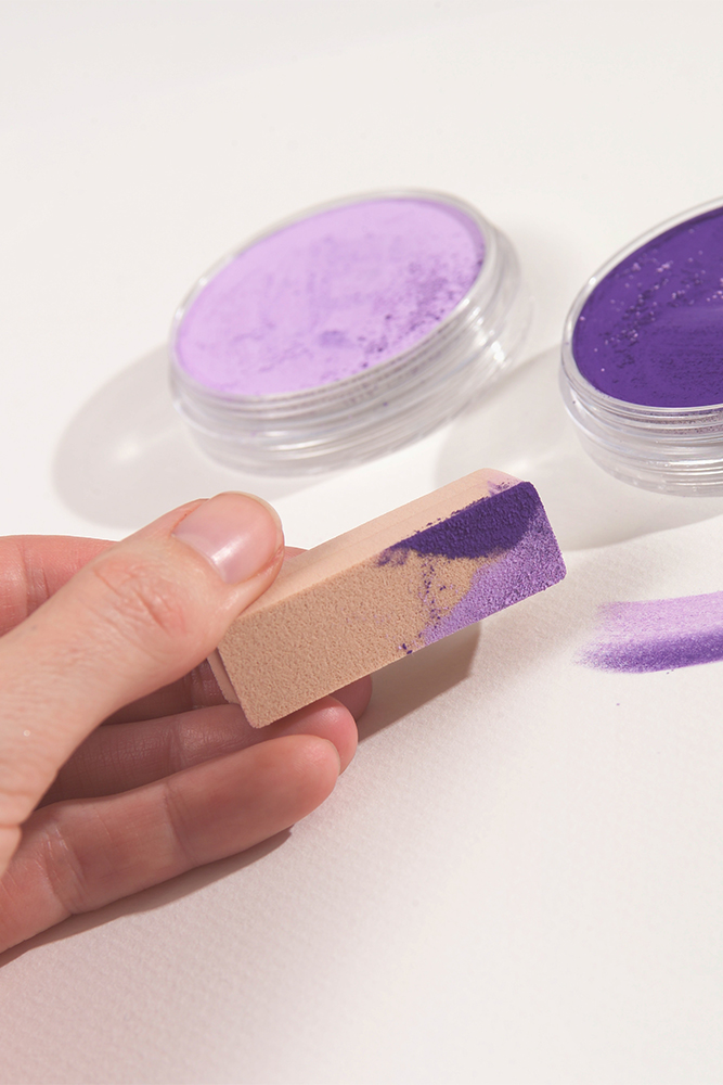 Artist using a purple PanPastel Soft Pastel with a Sofft Sponge Applicator