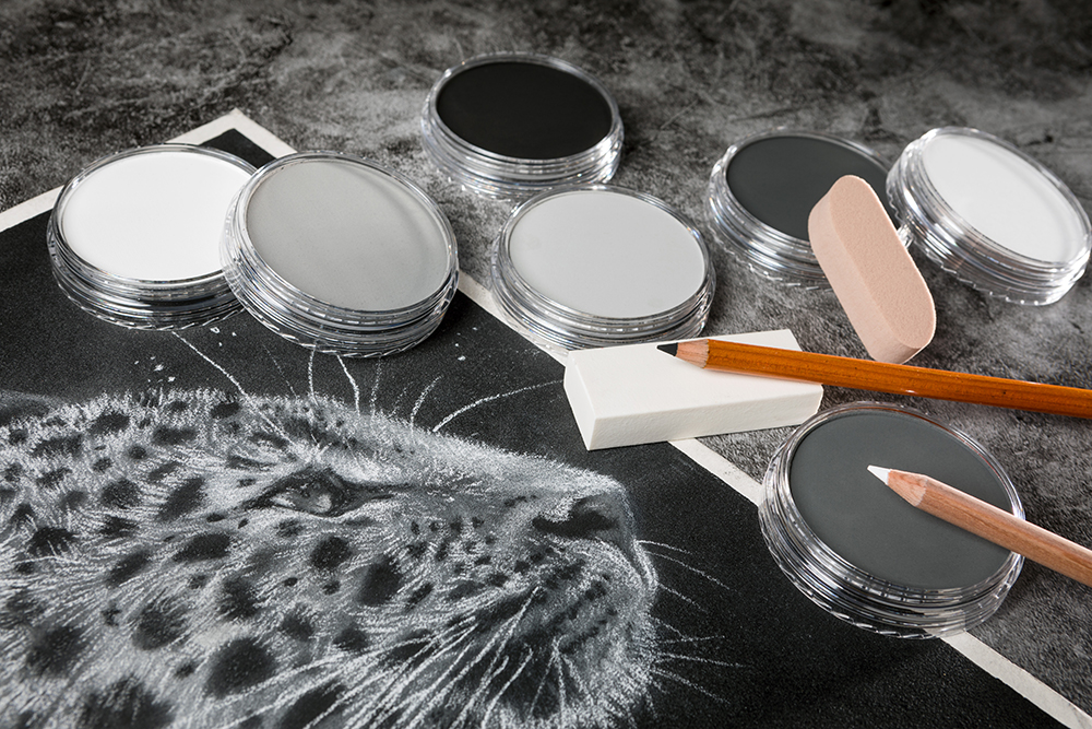 Grayscale PanPastel Soft Pastels and drawing materials with a detailed drawing of a leopard on black paper